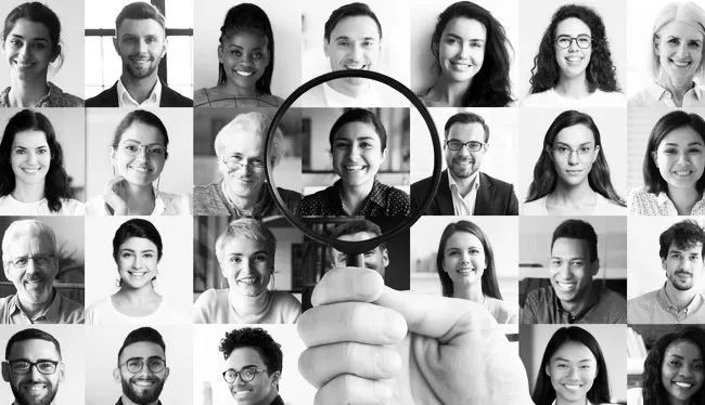 A mosaic of the faces of many diversity professionals is shown with a magnifying glass over the centre of the image. This image represents assessments to examine personality and develop individuals as part of a talent strategy.