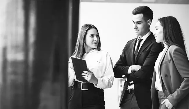 Three professionals engage in active discussion. They are reviewing the gender equality plan for their Australian workplace.